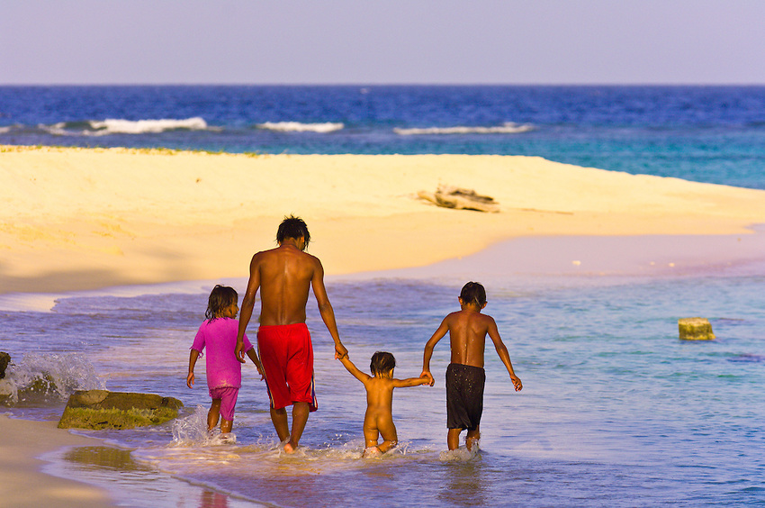 Family walking on the beach on Pelican Island (a.k.a. Icotupo Island), San Blas Islands (Kuna Yala), Caribbean Sea, Panama